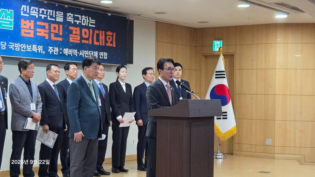태극기 옆 단상에서 발언하는 참석자와 뒤에 선 행사 관계자들