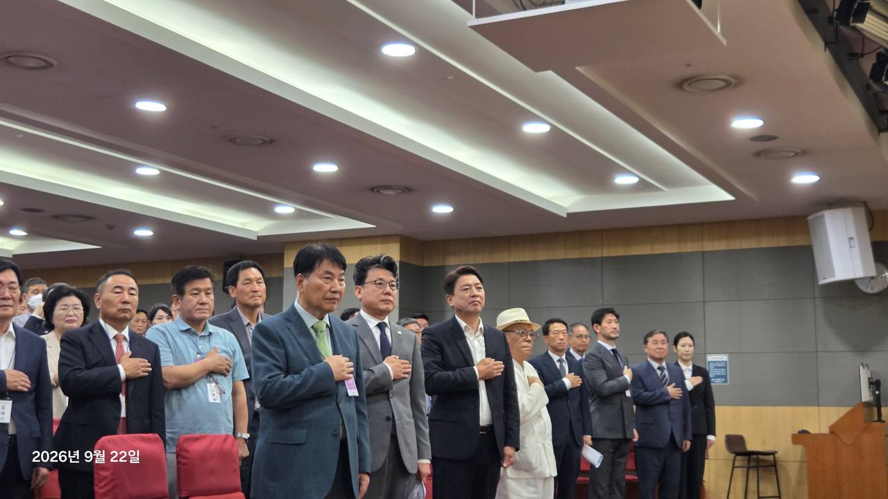 행사장에서 오른손을 가슴에 얹고 국민의례를 하는 참석자들