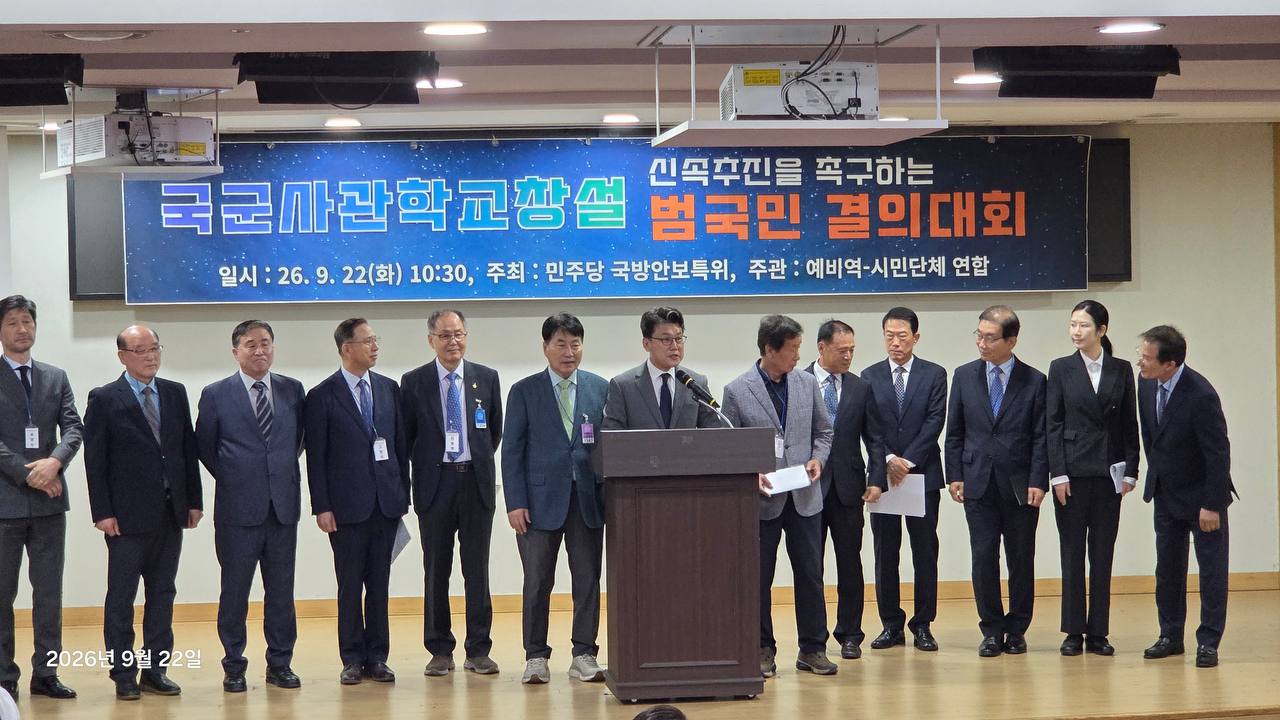 행사 현수막 아래 단상에 함께 선 참가자들과 중앙 발언자